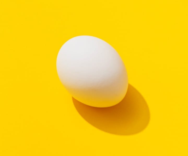 White egg on a yellow background